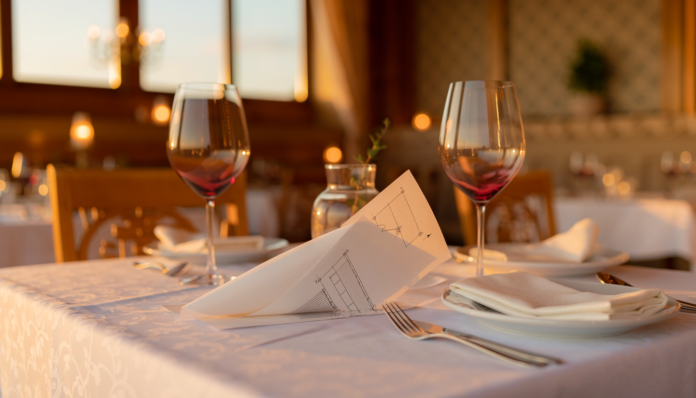 Firefly realistic photo of an empty restaurant table set for two with wine glasses and a fol 469804